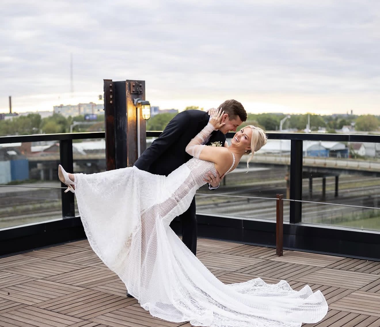 Bride and groom in a sunset dip pose on a rooftop